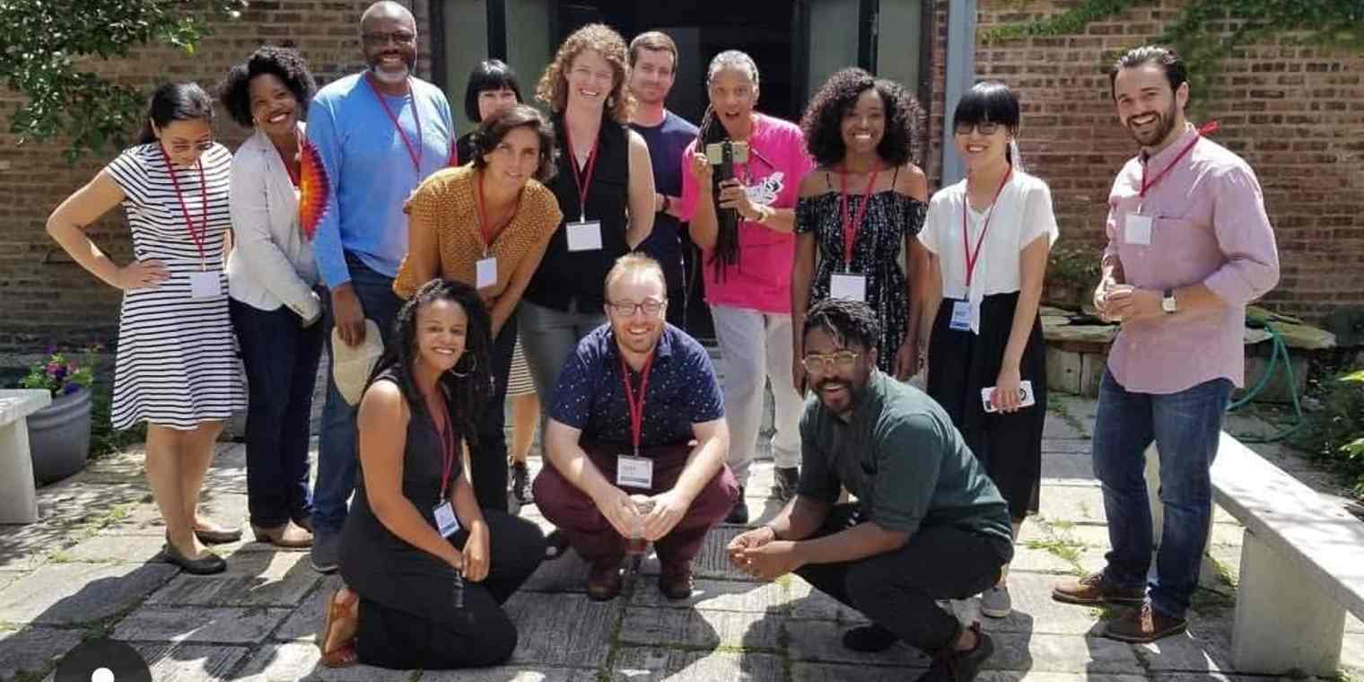 A group of people stand together outside a building. On the far right is Simon Galperin
