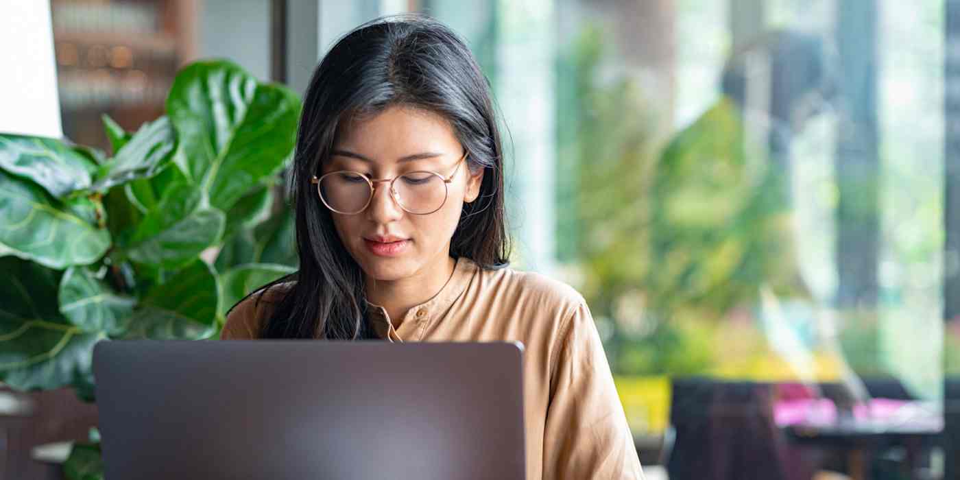 Hero image with a picture of a woman wearing glasses at a computer