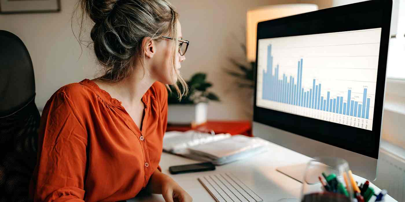 A hero image with a photograph of a woman looking at a graph on a computer screen