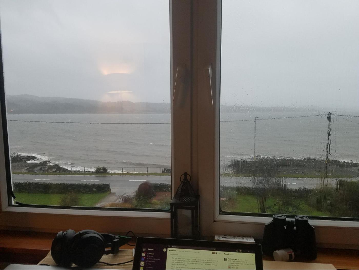 A picture of Leanna's computer, with Slack open, looking out over water