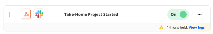 A yellow alert next to a Zap notifies the user that 14 Zap runs were held. 