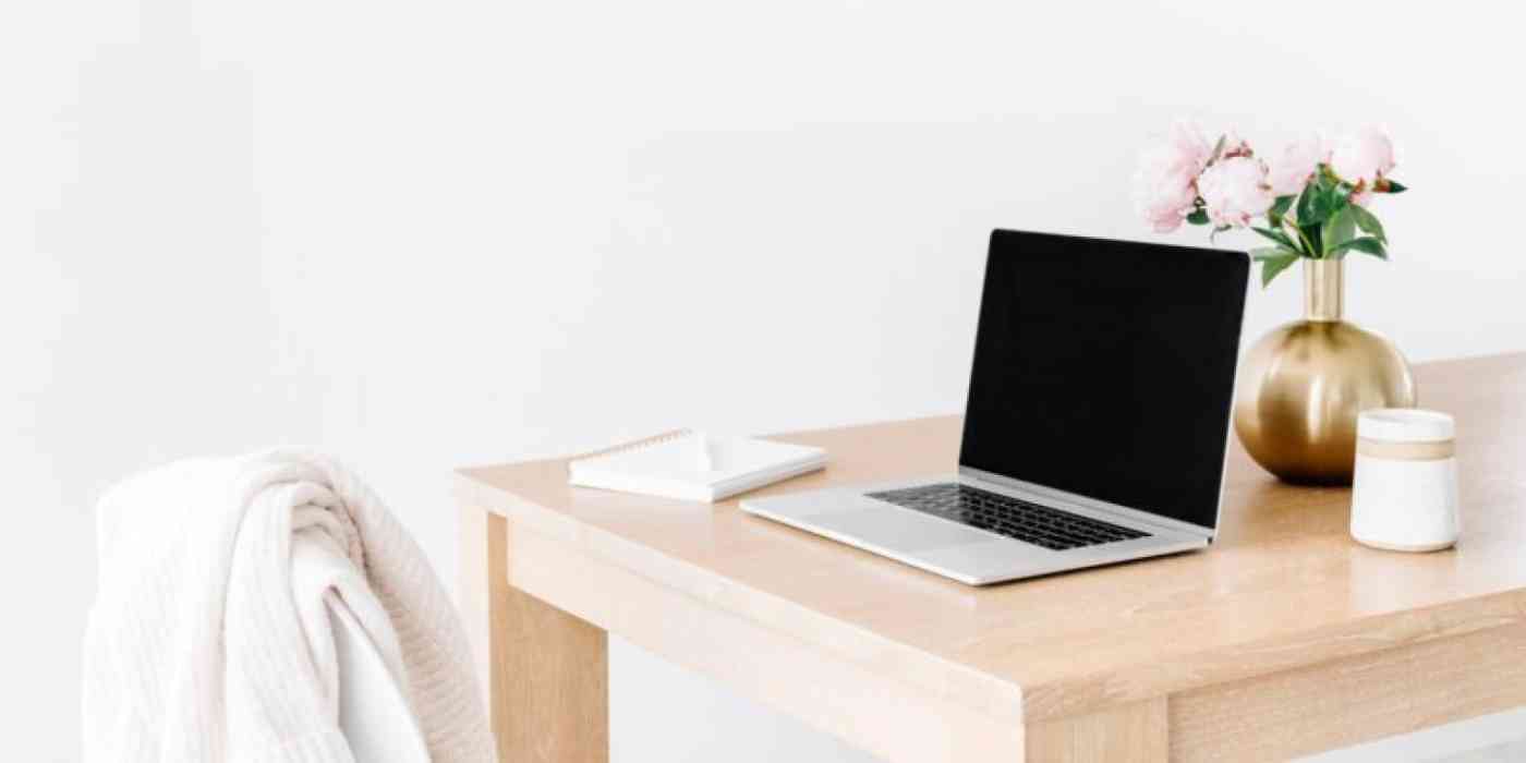 Hero image with a picture of a laptop on a modern desk, with a sweater over the chair