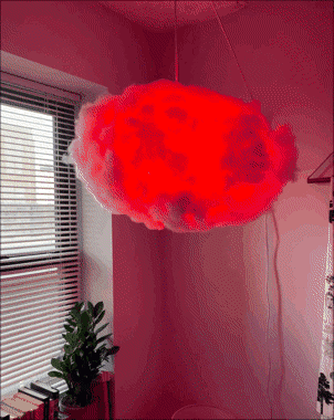 An animated GIF of a hanging cloud light. The light bulb changes from red, purple, blue, then pink. 