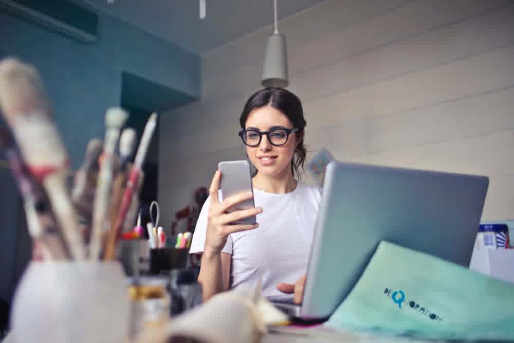 image of woman in front of a computer doing many things at once