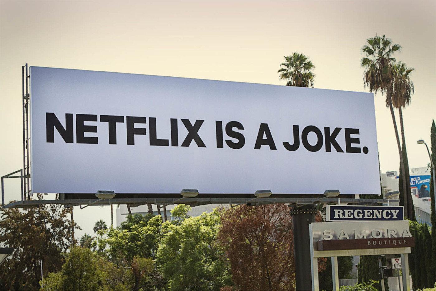 Photo of a white billboard with black letters reading NETFLIX IS A JOKE.