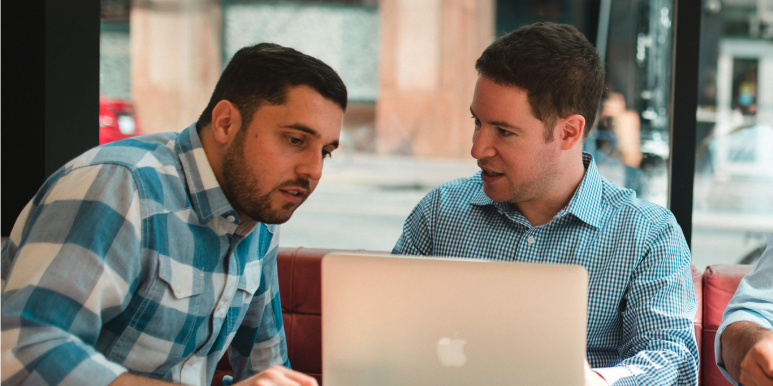 Hero image of two people talking to each other over a laptop