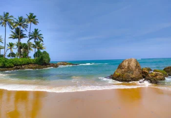 Unwind in Sri Lanka's coastal charm with TravelTaxi - The serene Unawatuna Beach.