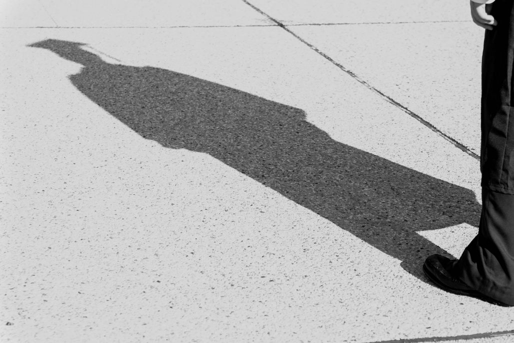 Shadow of a person wearing graduation garb.