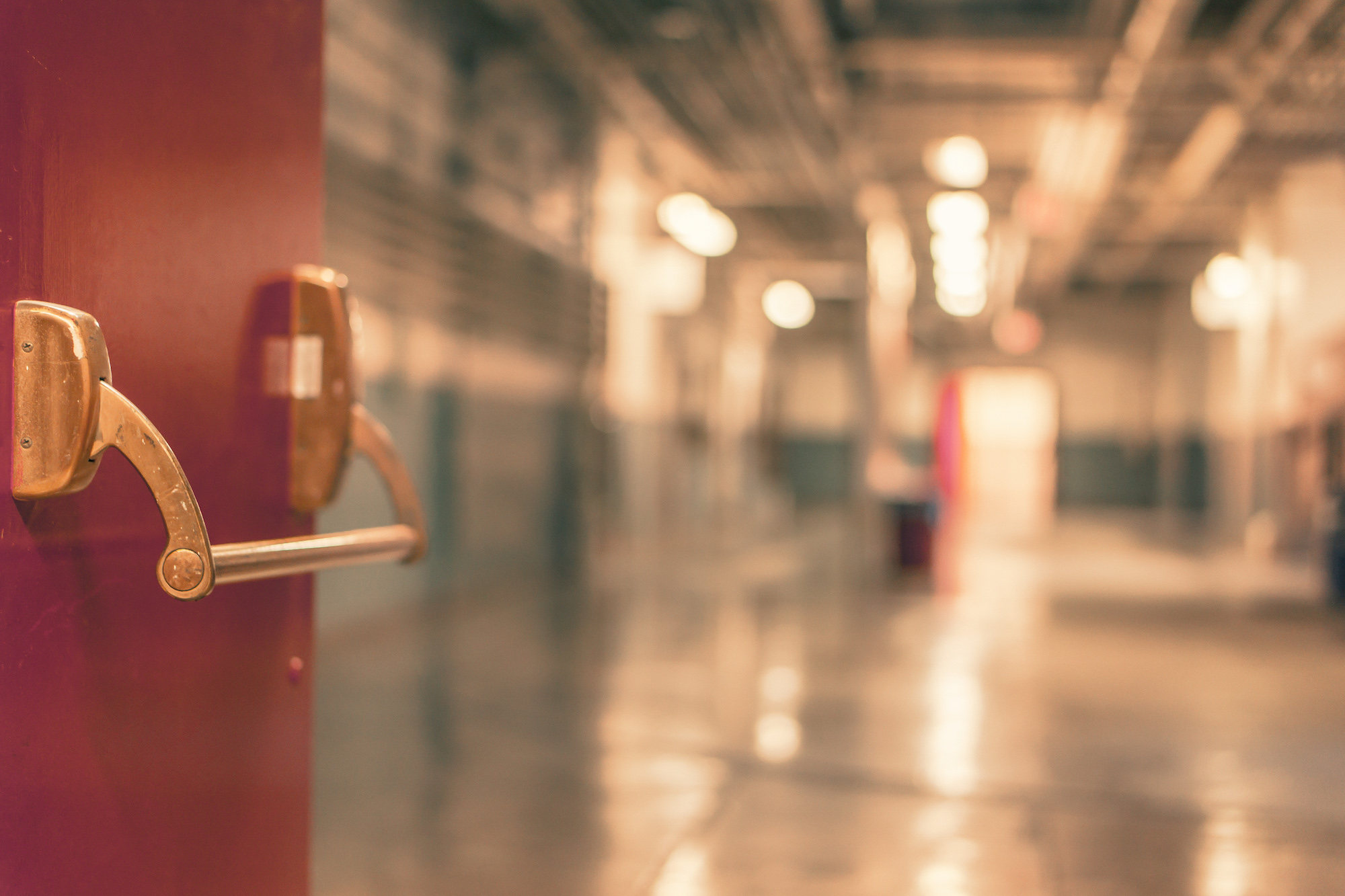 A red door open to a blurry hallway