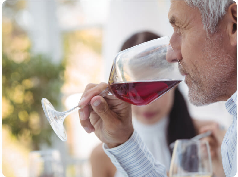 A man sipping a glass of dry red wine