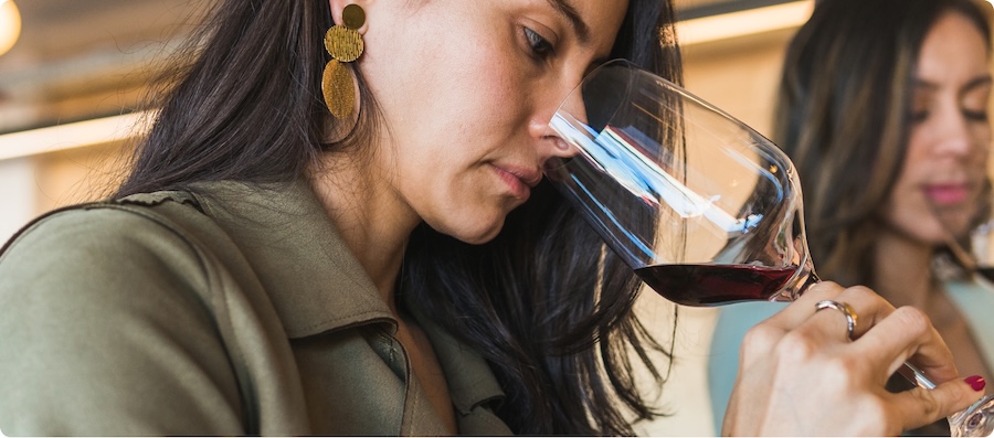 Woman smells glass of red wine