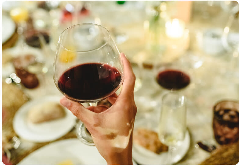 Holding a glass of red Tempranillo wine at the dinner table