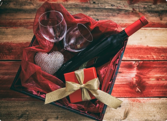 A gift box with red wine, wine glasses for Valentine's Day