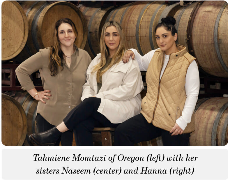A photo of three women in front of wine barrels. The caption below reads: "Tahmiene Momtazi of Oregon (left) with her sisters Naseem (center) and Hanna (right)"