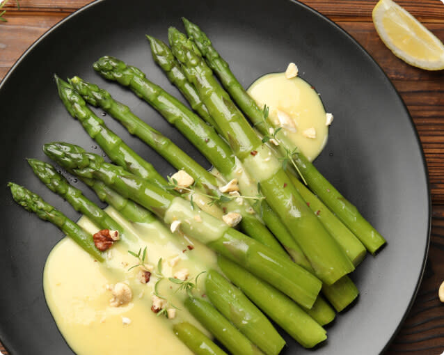 A plate of asparagus served with hollaindaise sauce; vegetarian food pairings with Chardonnay