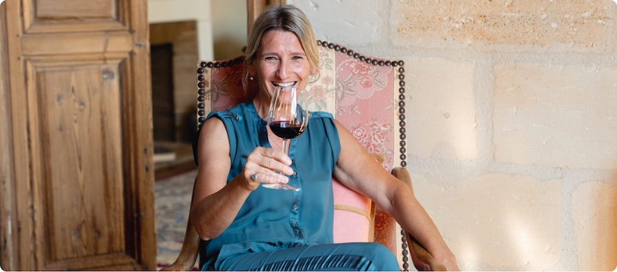 Brigitte Bourlon of Chateau Guibeau holding a glass of red wine