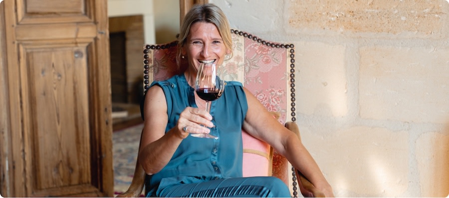 Brigitte Bourlon of Chateau Guibeau holding a glass of red wine