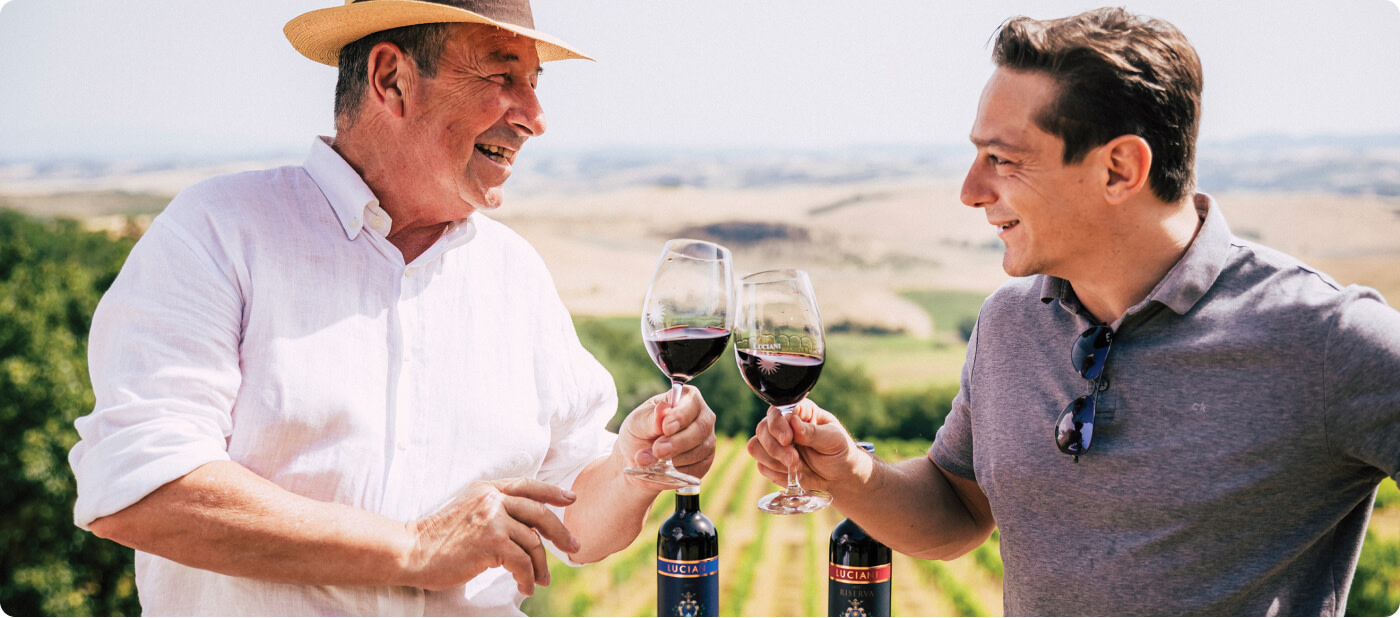 Winemaker Mario Luciani with WSJ Italian wine expert, Leo, toasting with glasses of red wine in Tuscany
