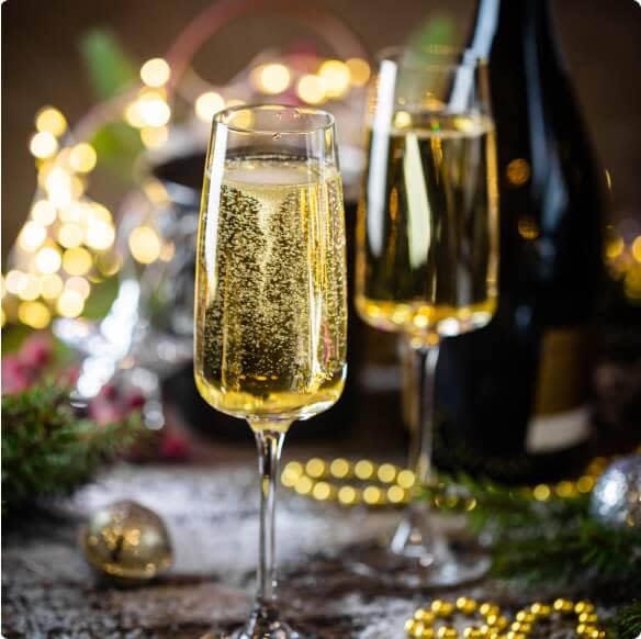 Glasses of sparkling wine on a table set for Christmas dinner