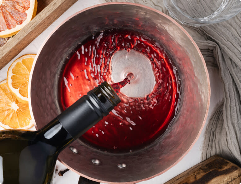Pouring red wine into a pot to make mulled wine