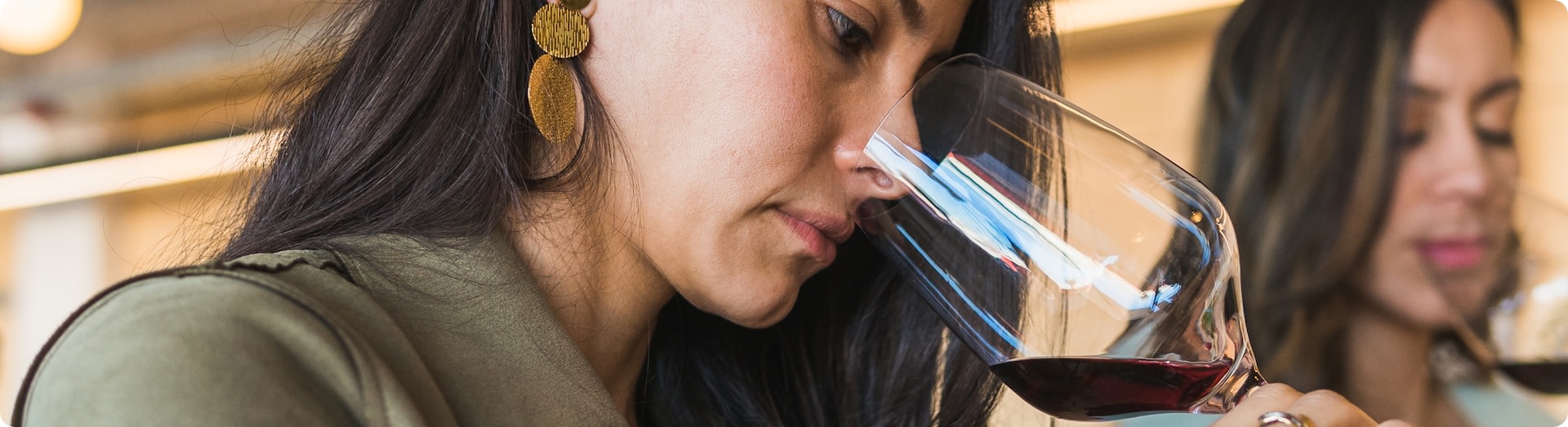 Woman smells glass of red wine