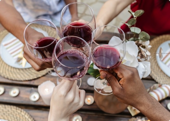 Hands toasting with glasses of red non-alcoholic wine