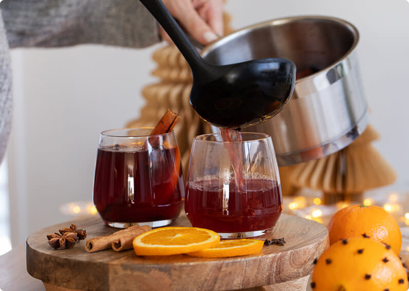 Ladling warm mulled wine into glasses