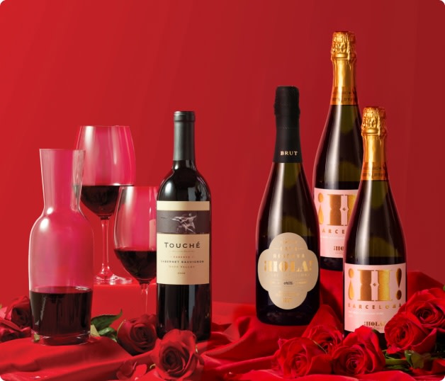 Bottles of wine on a red backdrop with roses for Valentine's Day gifting