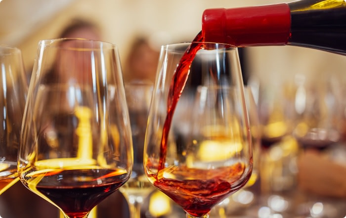 Pouring red wine into glasses for a wine tasting
