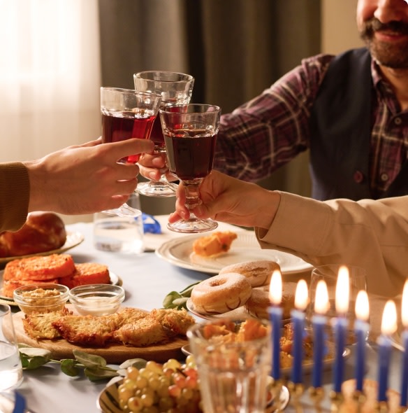 Hanukkah dinner guests toasting with red wine 