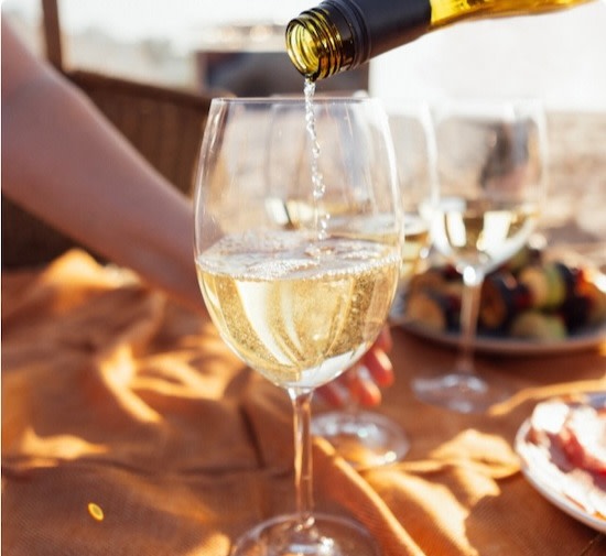 Glasses of white wine on a picnic blanket