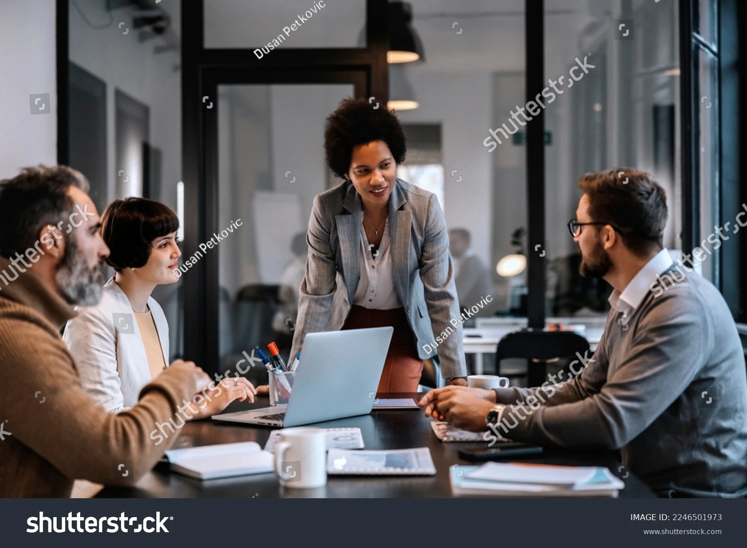 stock-photo-a-multiracial-businesswoman-is-standing-at-the-boardroom-and-listening-to-proposals-while-looking-2246501973