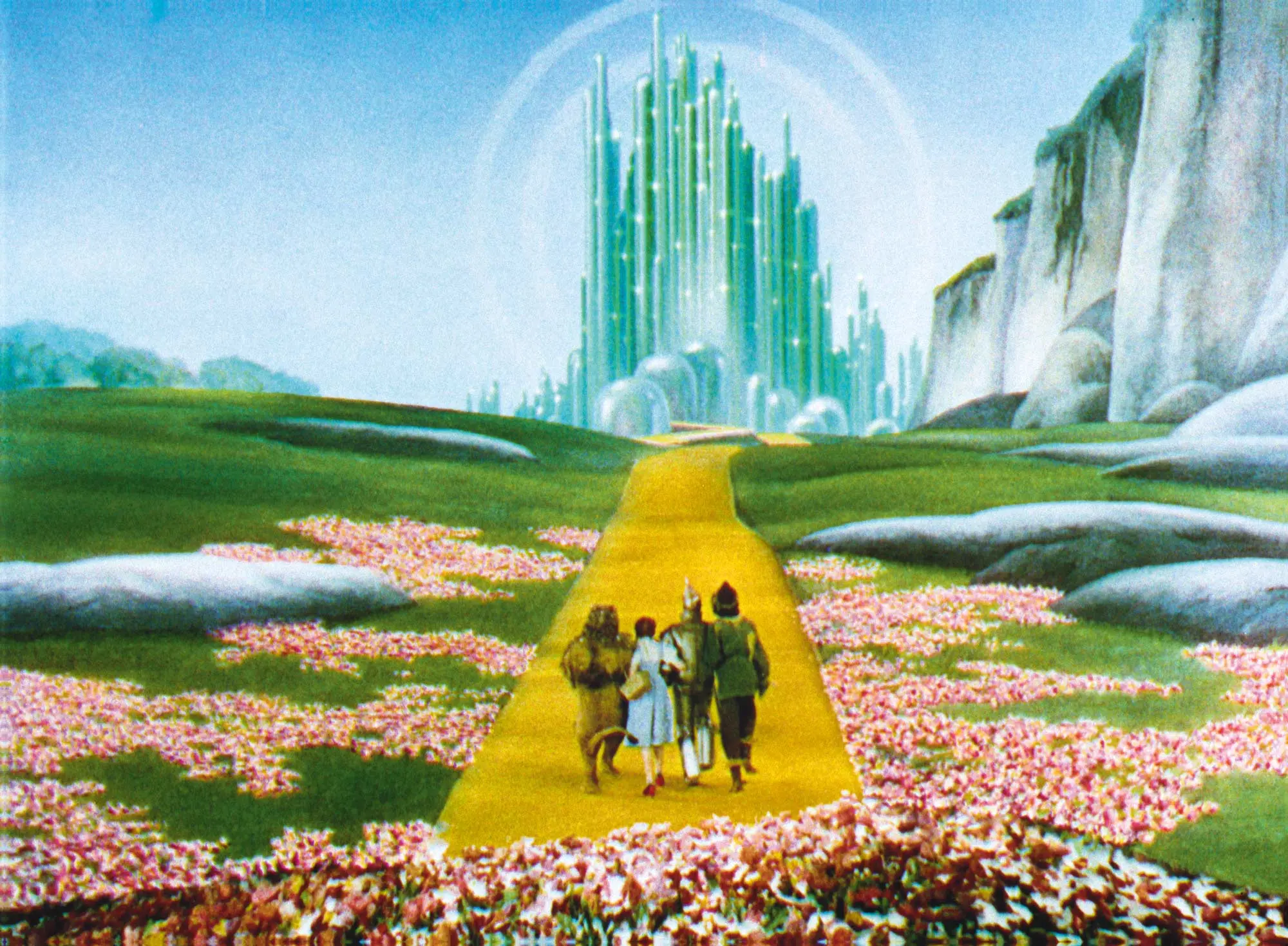 Still from film of Dorothy and her friends on the yellow brick road leading to the Emerald City. THE WIZARD OF OZ and all related characters and elements © & ™ Turner Entertainment Co.