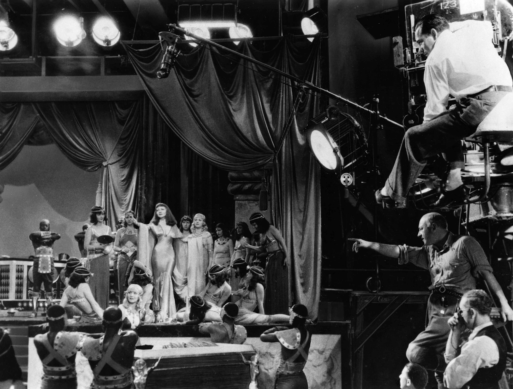 Claudette Colbert (center), director Cecil B. DeMille (lower right corner), cinematographer Victor Milner (looking through a viewfinder), and others during production of Cleopatra (1934), Bison Archives photographs collected by Marc Wanamaker, courtesy of Margaret Herrick Library, Academy of Motion Picture Arts and Sciences.