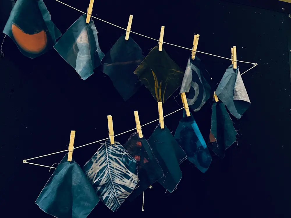 Blue cloth hanging on a clothesline with clothespins.