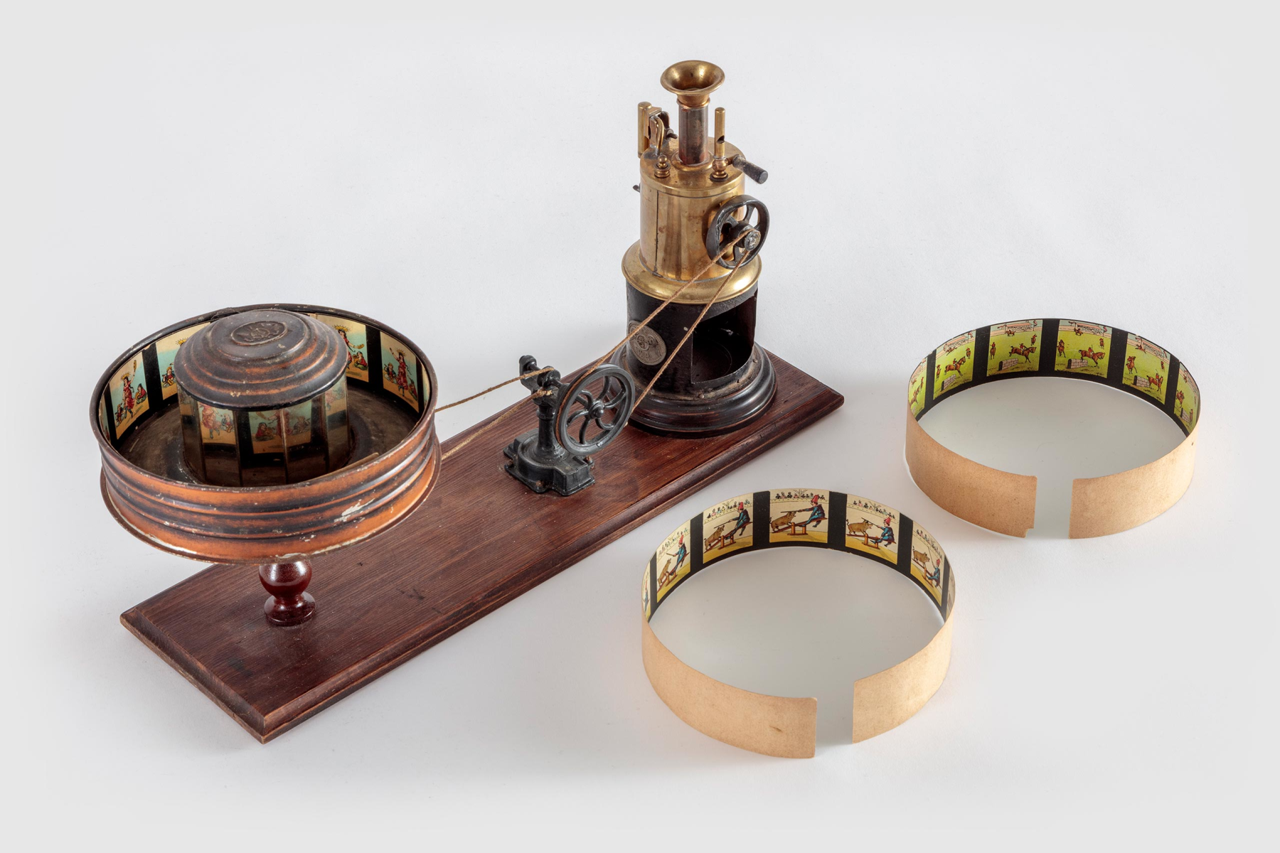 Steam-Driven Praxinoscope with Animation Strips, Ernst Plank, Wood, tin, brass, paint, glass mirror, and cotton string with print on paper strips, c. 1904, Germany, from the Richard Balzer Collection, gift of Patricia Bellinger Balzer, Photo by Joshua White/JW Pictures, ©Academy Museum Foundation