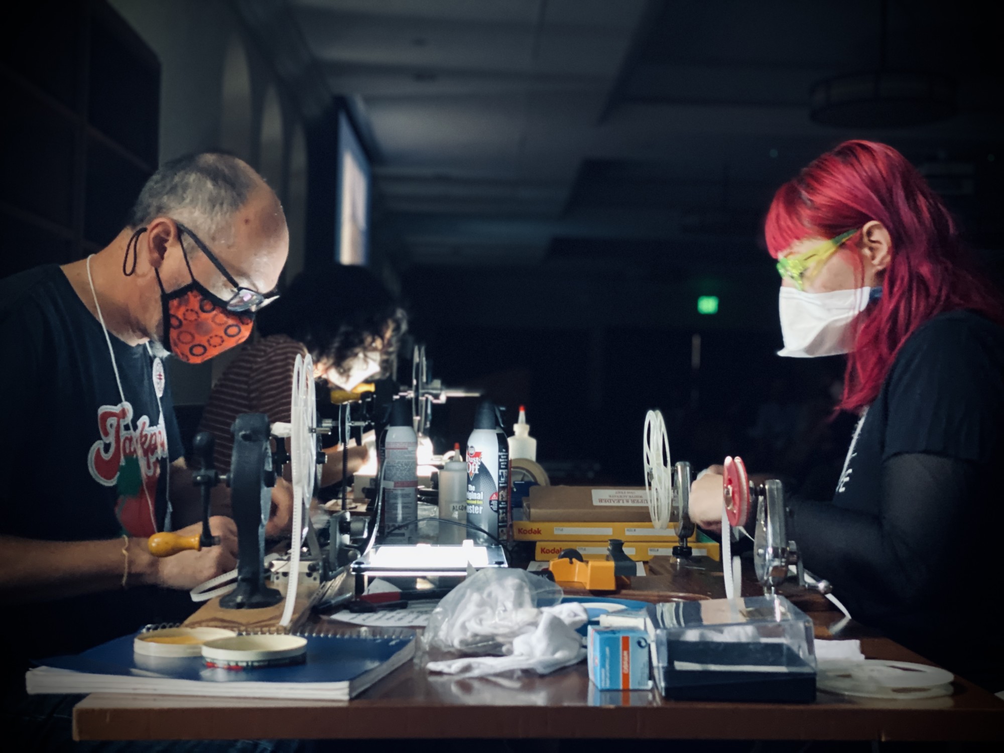 Individuals inspecting film strip on a table