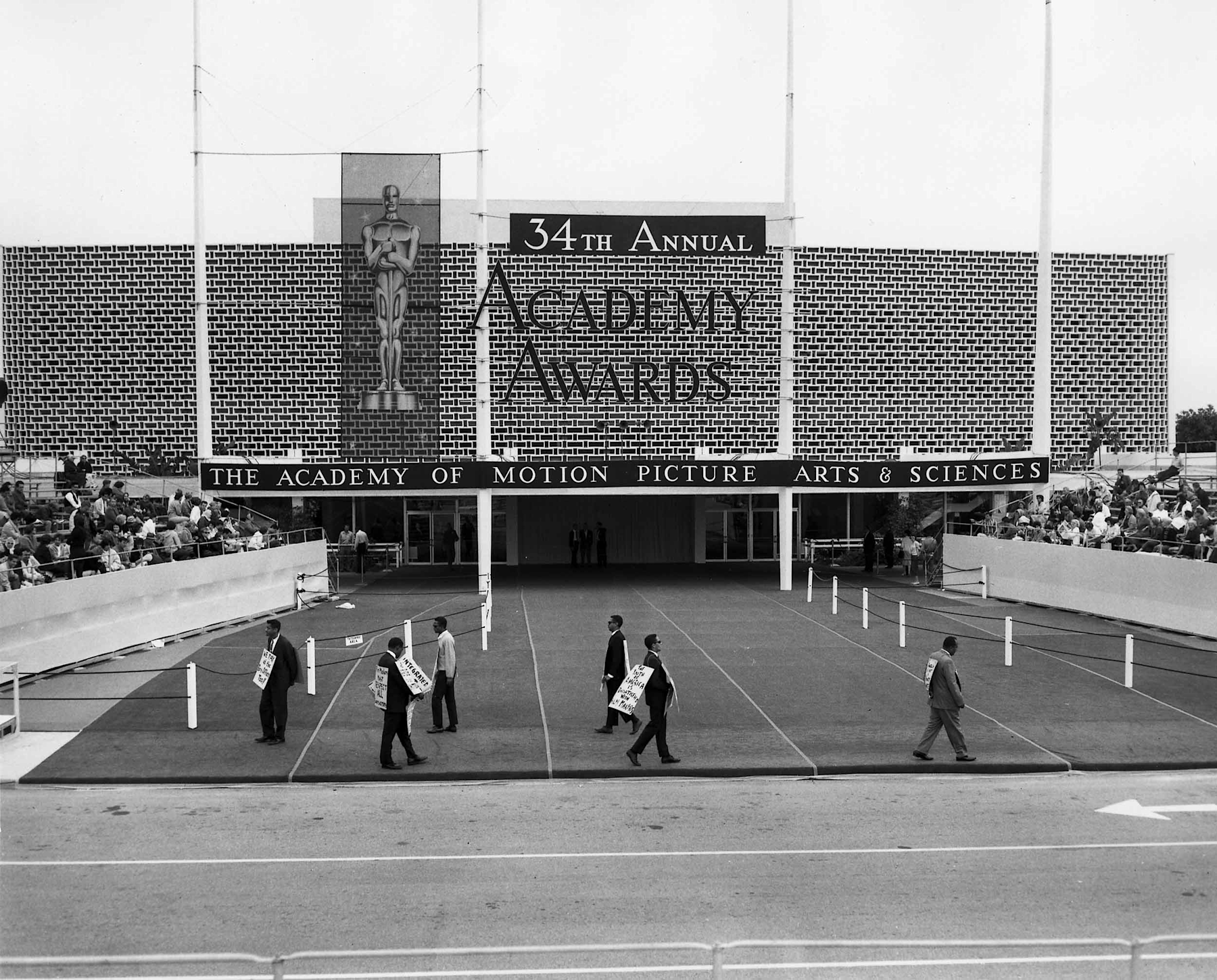 African American protesters picket outside the Santa Monica Civic Auditorium at the site of the 1963 Academy Awards ceremony with placards reading, “We pay at the box office too,” “Filmmakers must respect all consumers,” and “The youth of America is dissatisfied with filmmakers.” 

Courtesy of Academy Awards show photographs, Margaret Herrick Library, Academy of Motion Picture Arts and Sciences 