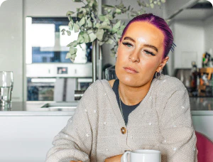 Woman sitting in a kitchen with a mug