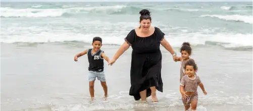 Woman and three children playing in the sea