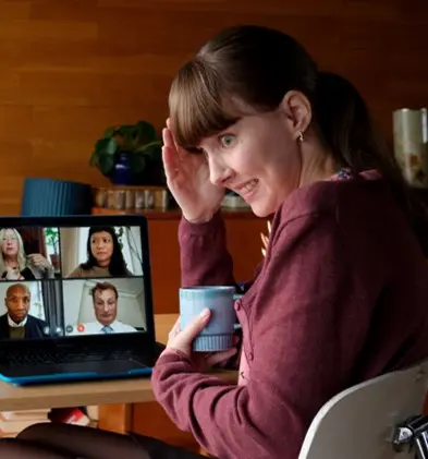 Kvinna som ser generad ut under ett videomöte med fyra personer.