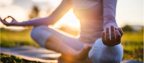 Person practicing yoga in the morning outdoors