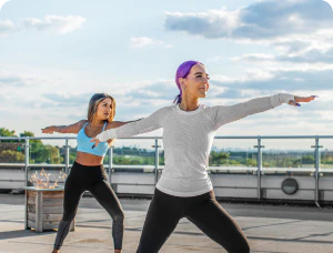 Two women doing yoga exercises outdoors