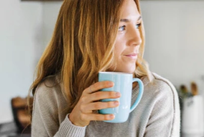 Woman by a window holding a mug