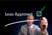 An underwriter writing Loan Application approved