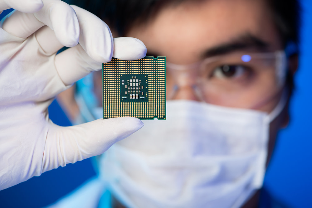 Cropped image of an engineer showing a computer chip in the foreground
