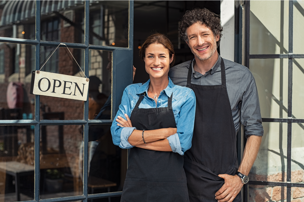 Two cheerful small business owners smiling and looking at camera