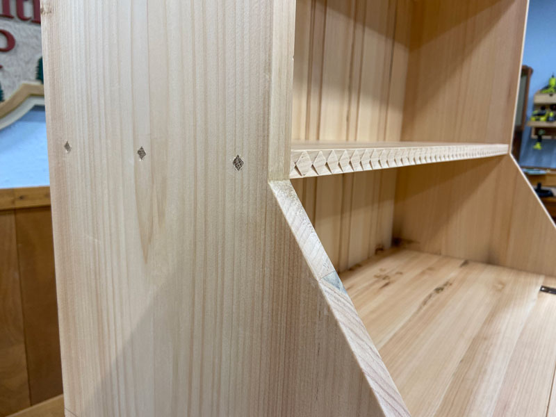 Phil's desk closeup of carved diamond molding and wood pegs