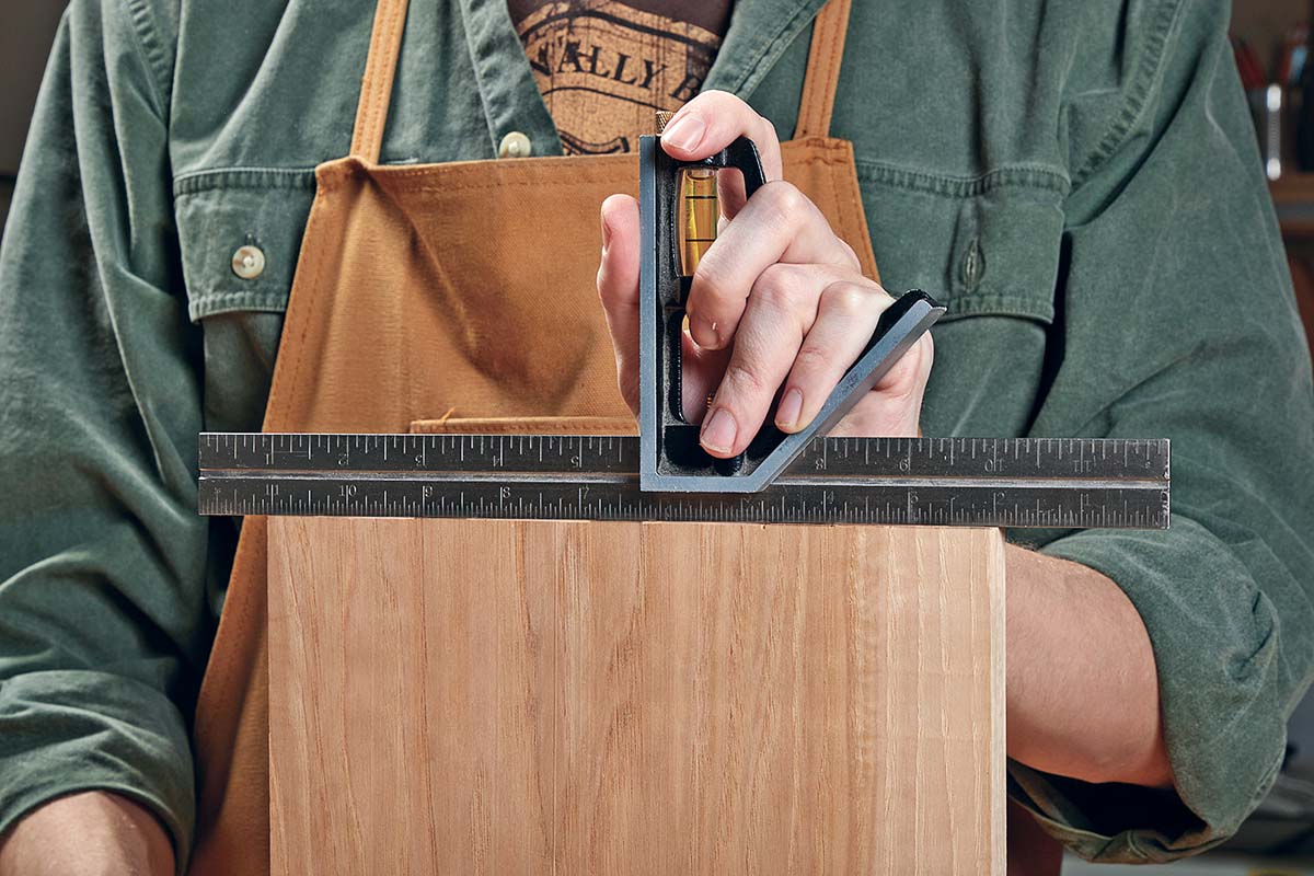 checking end of wood is square with ruler and handheld level