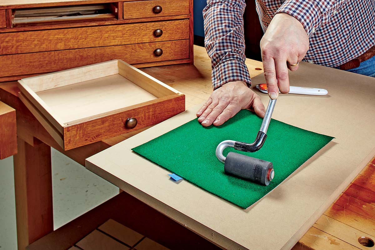 using roller to smooth felt down on posterboard